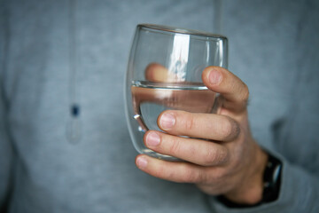 Man drinks water, Close-up shot of man holding glass of fresh water, Quenching thirst, Lifestyle...