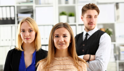 Group of smiling people stand in office looking in camera