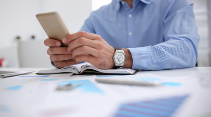 A businessman holds a new smartphone in his hand