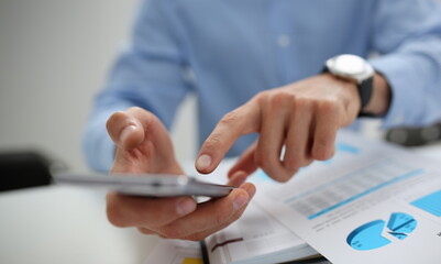 A businessman holds a new smartphone in his hand
