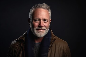 Portrait of a handsome senior man with grey hair and beard wearing a brown jacket.