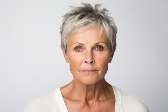 Portrait of a senior woman with grey hair against a grey background