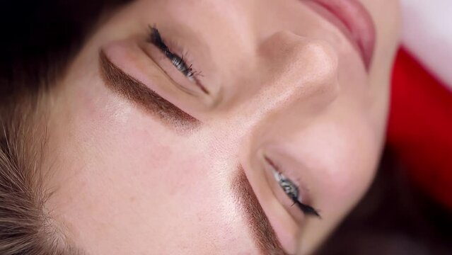 Result after permanent eyebrow makeup, young beautiful girl posing on camera Permanent makeup procedure, performing PMU of eyebrows