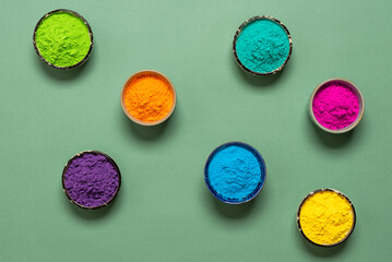 Colorful Holi powders in bowls on green pastel paper background. Top view, flat lay. - 745743536