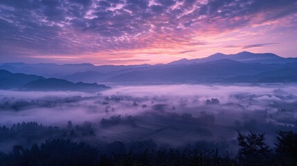Naklejka premium Beautiful purple misty sunrise mountain view landscape with Spindrift clouds and agricultural fields