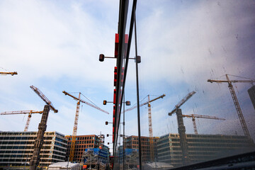 Reflection of a construction site in a window - obrazy, fototapety, plakaty