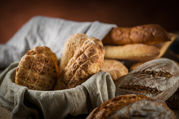 Assortment of baked bread on wooden table background