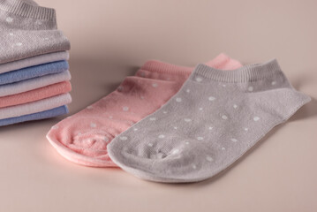 Pink and Gray Polka Dot Socks and Stack of Socks on pastel background