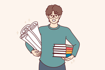 Man student with textbooks and papers for creating engineering drawings, smiles and looks at screen. Guy student studying at university or college holds books recommended by teacher