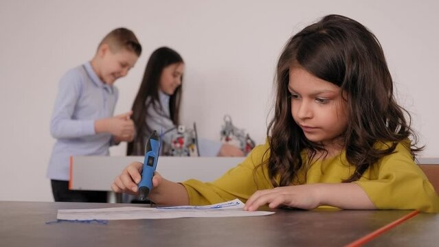 Portrait of a girl student at a computer school, she makes a 3d model using a 3d pen. A cute little girl makes a plastic house, draws details with a 3D pen.