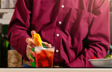 Man in magenta shirt preparing colorful cocktail - 745773787