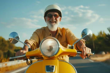 Poster Elderly man with white beard cruising on sunny day with yellow retro scooter by the coast © Nadzeya