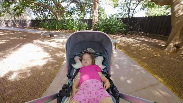 A naptime stroll through a lush garden with a sleeping baby in 4k slow motion 60fps