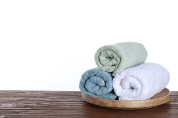 Fresh towels on wooden table against white background. Space for text