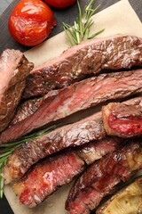 Delicious grilled beef with tomatoes and rosemary on table, top view