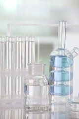 Laboratory analysis. Different glassware with liquid on white table against blurred background