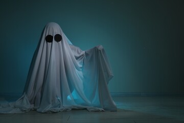Creepy ghost. Woman covered with sheet on dark teal background, space for text