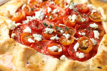 Tasty galette with tomato, thyme and cheese (Caprese galette) as background, closeup