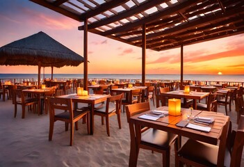 Outdoor restaurant at the beach. Tables at beach restaurant. Led light candles and wooden tables, chairs under beautiful sunset sky, sea view. Luxury hotel or resort -