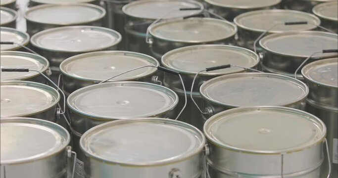 Cans with material on a construction site. A lot of metal cans at a construction site. Paint cans are lined up in rows.