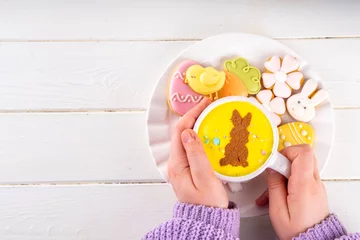 Fotobehang Hot sweet drinks for Easter party, breakfast, lunch. Easter menu. Pink, yellow, blue, brown multicolored hot chocolate cups with marshmallows, chocolate drawing rabbit, Easter eggs on latte surface © ricka_kinamoto