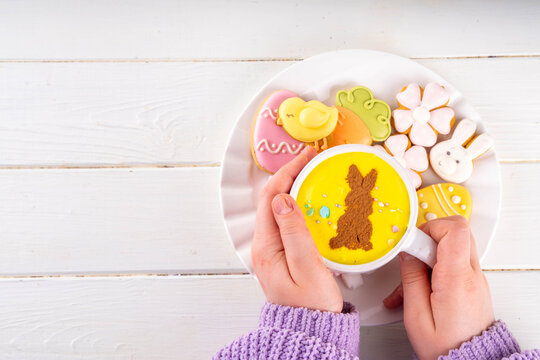 Hot sweet drinks for Easter party, breakfast, lunch. Easter menu. Pink, yellow, blue, brown multicolored hot chocolate cups with marshmallows, chocolate drawing rabbit, Easter eggs on latte surface