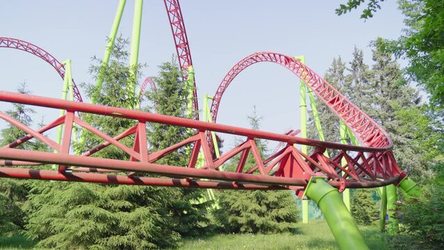 Roller coaster Ride against blue sky. Roller coaster in the amusement park. Cheerful entertainments in park of attractions