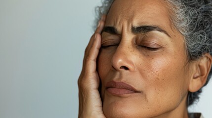 Woman with closed eyes hand on forehead showing concern or deep thought.
