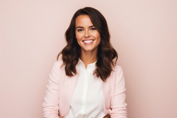 Portrait of a happy young business woman standing against pink background.