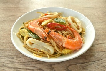 spicy stir fried spaghetti seafood couple squid shrimp with chili and basil leaf in sauce on plate 