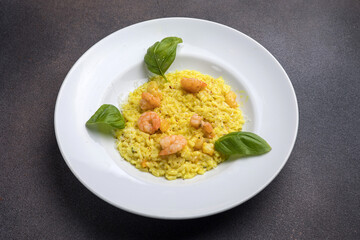 Risotto with shrimps and basil on a white plate