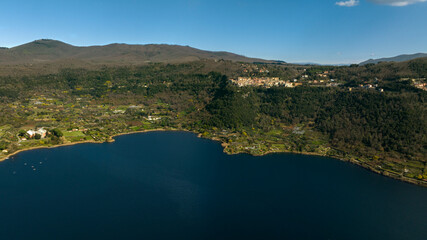 Obraz premium Aerial view of Nemi, a town of Castelli Romani regional park, in the Metropolitan City of Rome, Italy. The historic center is located in the Alban Hills overlooking Lake Nemi, a volcanic crater lake. 