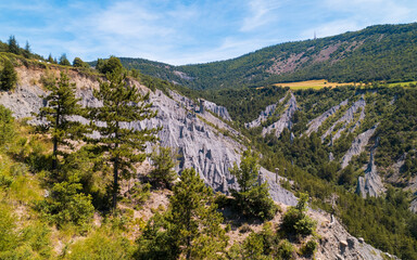 Aerial photography by drone of the rock formations, the Demoiselles Coiffées in Serre-Ponçon and its mountains, located in the Hautes-Alpes in France