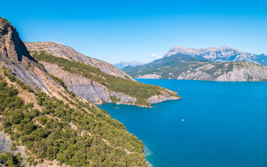 Aerial photography by drone of the Serre-Ponçon lake and its mountains, located in the Hautes-Alpes in France
