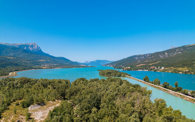 Aerial photography by drone of the Serre-Ponçon lake and its mountains, located in the Hautes-Alpes in France