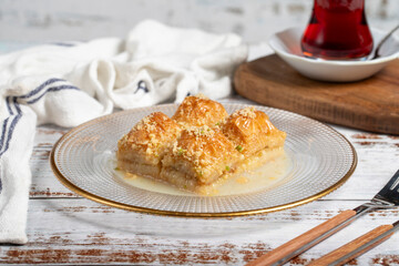 Baklava with milk. Milk baklava with hazelnuts on a white background. Local name sütlü nuriye baklava