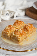 Baklava with milk. Milk baklava with hazelnuts on a white background. Local name sütlü nuriye baklava. Close up