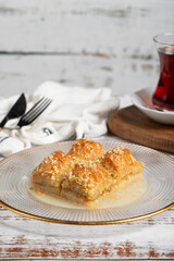 Baklava with milk. Milk baklava with hazelnuts on a white background. Local name sütlü nuriye baklava