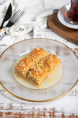 Baklava with milk. Milk baklava with hazelnuts on a white background. Local name sütlü nuriye baklava. Close up
