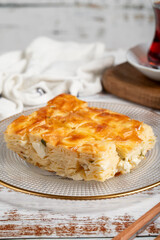 Cheesy borek. Bakery products. Cheese pastry on a white background. local name peynirli su börek. Close up