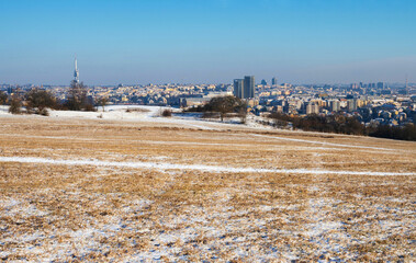 Wide snowy meadow and building and tower in Prague. - 745813159
