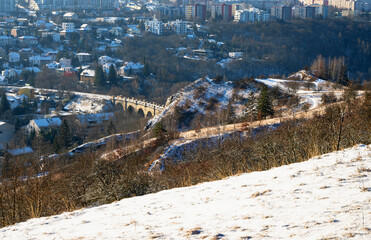 Viaduct in city district Hlubocepy and building, from snowy meadow, Prague. - 745813353