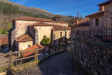 Church of the beautiful village of Carmona with mountain typical stone houses in a sunny day. Cantabria, Spain.