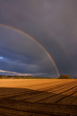 a double rainbow over an agricultural field