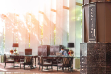 Concierge service lounge signage, reception desk counter at frontdesk of hotel with hospitality staff team working for tourist guest or business customer