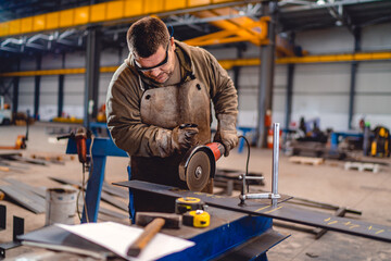 Fototapeta na wymiar Factory worker cutting metal with grinder.