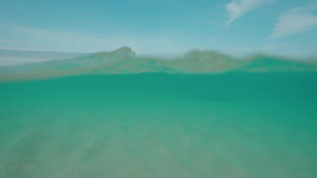 Clean ocean water and white sand beach close-up underwater dome split half half shot
