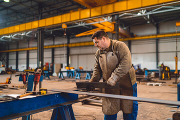 Industrial worker measuring the steel plate