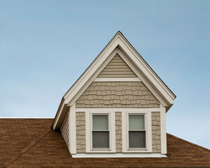 Close-up view of gabled dormer window on a sloped house roof in Brighton, MA, USA