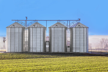 silver silos in the field © travelview